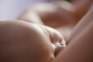 Baby angeschmiegt an Körper der Mutter