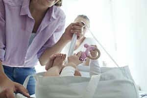 Baby liegt im Bett und sieht Mobile