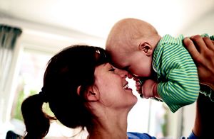Mutter hält Baby im Arm, Stirn an Stirn