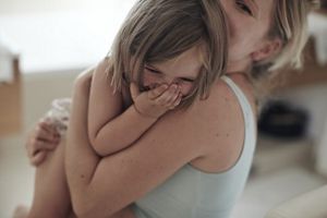 Kind lacht auf dem Arm von Mama