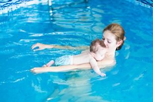 Frau mit Baby schwimmt