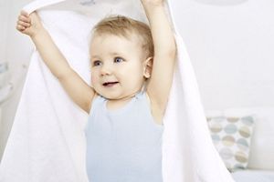 baby with arms in the air holding blanket