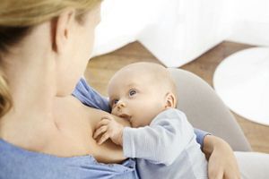 Breastfeeding baby on mothers breast