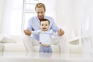 Vater hält Kind an den Händen