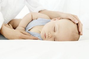 parent holding sleeping babys head