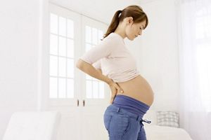 Schwangere schaut auf ihren Bauch