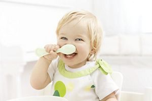 toddler holding spoon to his nose