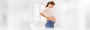 Schwangere schaut auf ihren Bauch