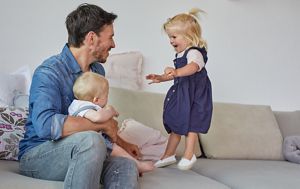 Kind lacht und wird von Mama geküsst