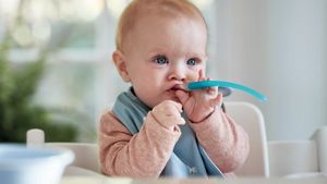 Baby Holding Spoon