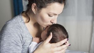 Mum Kissing Newborn On Forehead