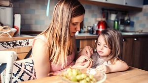 Toddler Peeling Grapes With Mum