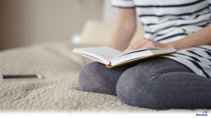 Woman-sitting-in-bed-reading-book