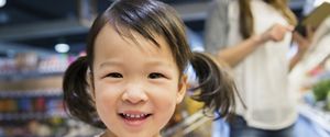 Petite fille souriante dans un supermarché